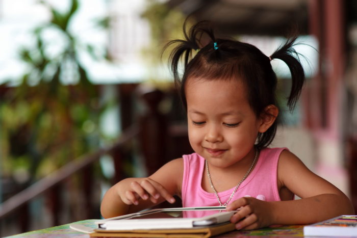 Happy child staring tablet.